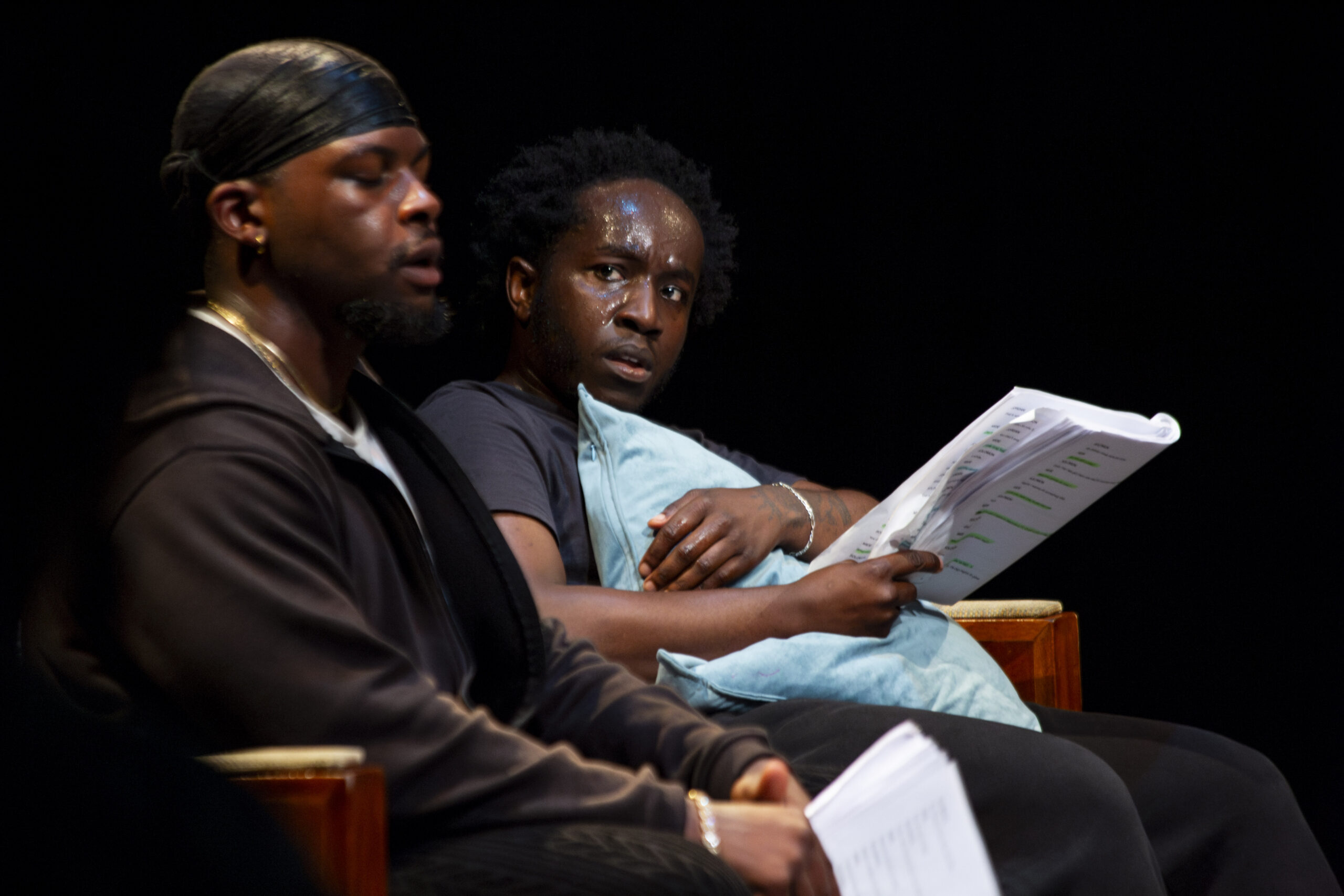 Production still from Thicker Than Water — two actors with scripts in hand during staged reading